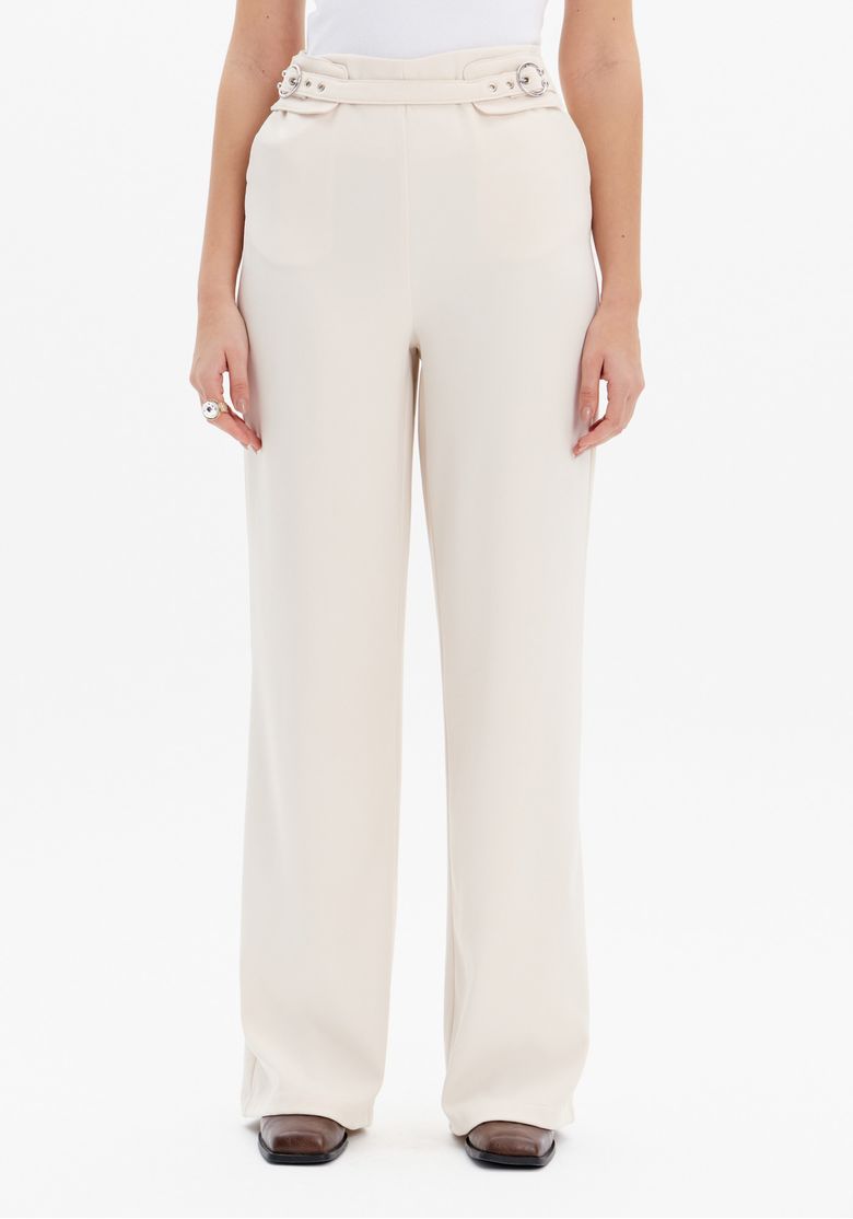 Vista traseira da calça full length bege em modelo, mostrando caimento longo e acabamento liso no verso