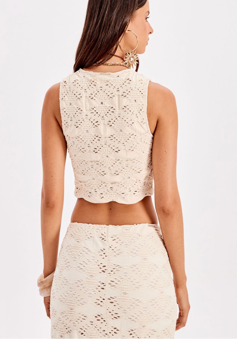 Modelo usando a blusa cropped com saia longa combinando.