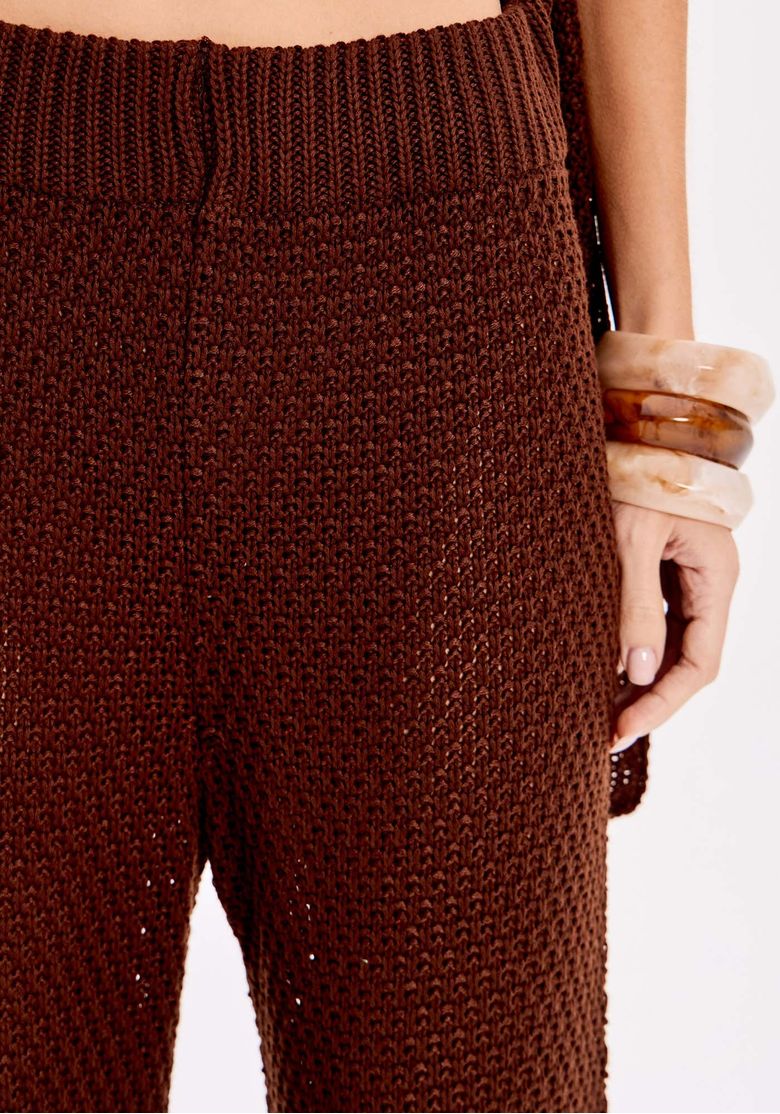 Detalhe frontal da calça tricô marrom mostrando textura encorpada e cós canelado