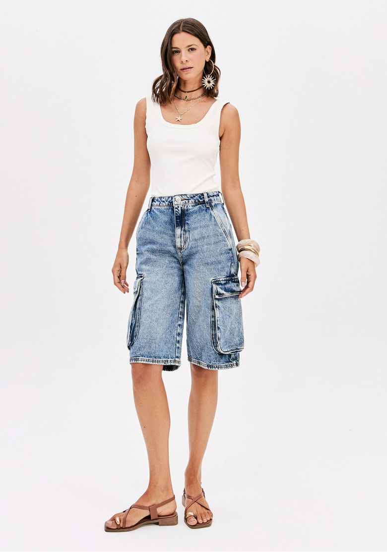 Modelo vestindo bermuda jeans cargo com cintura alta e top branco, vista frontal.