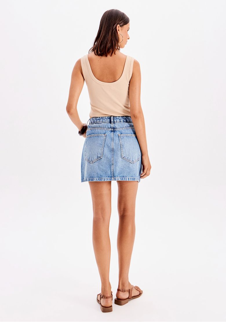Vista traseira da saia jeans curta com bolsos traseiros e caimento ajustado.