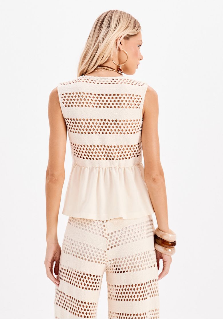 Vista traseira da blusa feminina sem mangas branca com linho e barra peplum, combinada com calça ampla texturizada