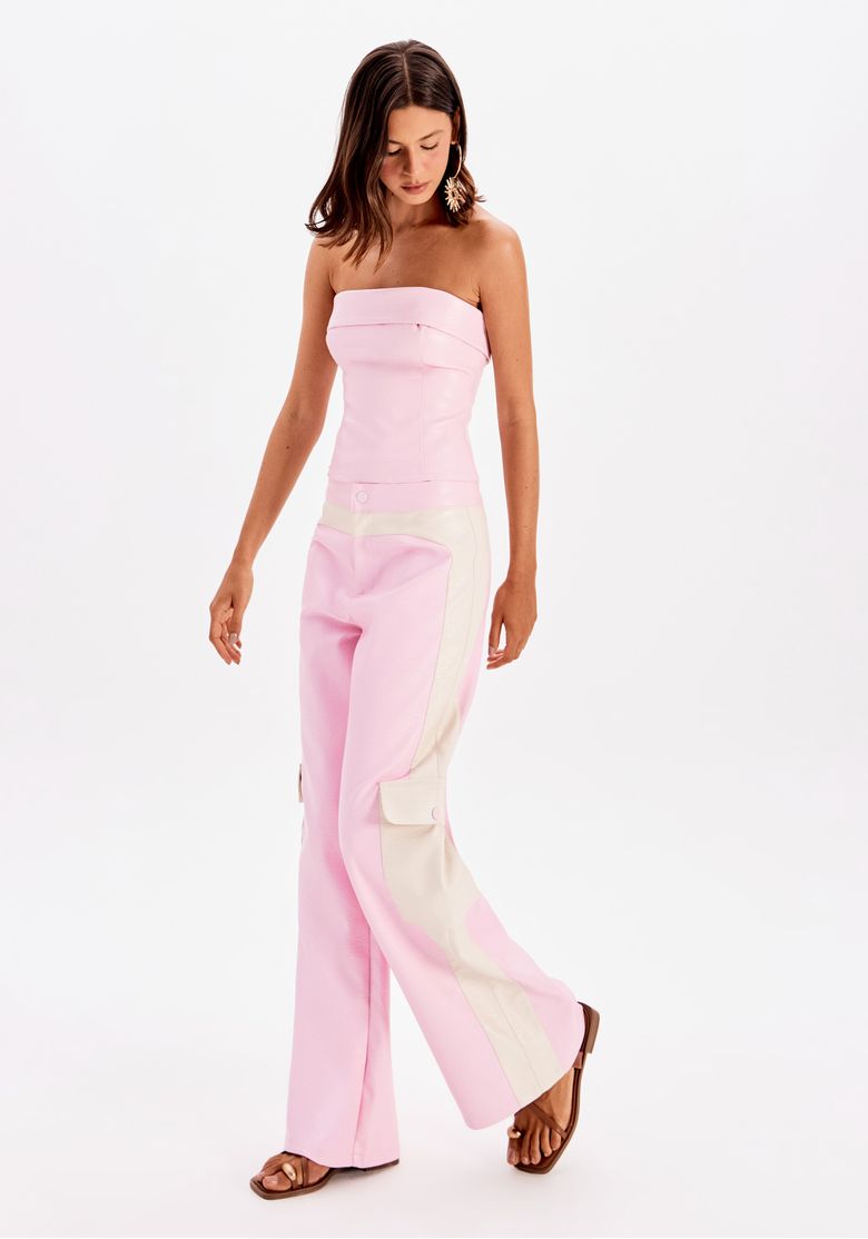 Modelo vestindo calça reta bicolor rosa com detalhes em bege, vista frontal.