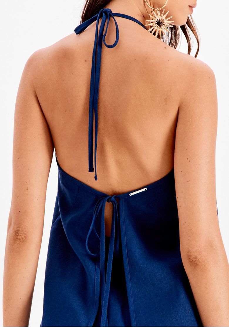 Vista traseira da blusa frente única azul com costas abertas e amarração dupla, combinada com calça pantalona