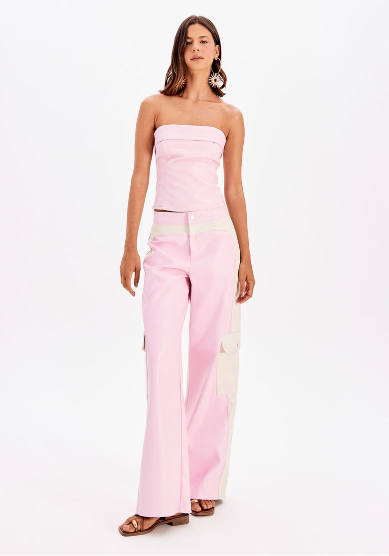 Modelo usando conjunto com calça reta bicolor rosa e top sem alças.