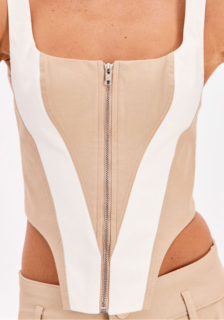 Look completo com blusa corset bege estruturada de alças largas e calça bege ampla com barra contrastante
