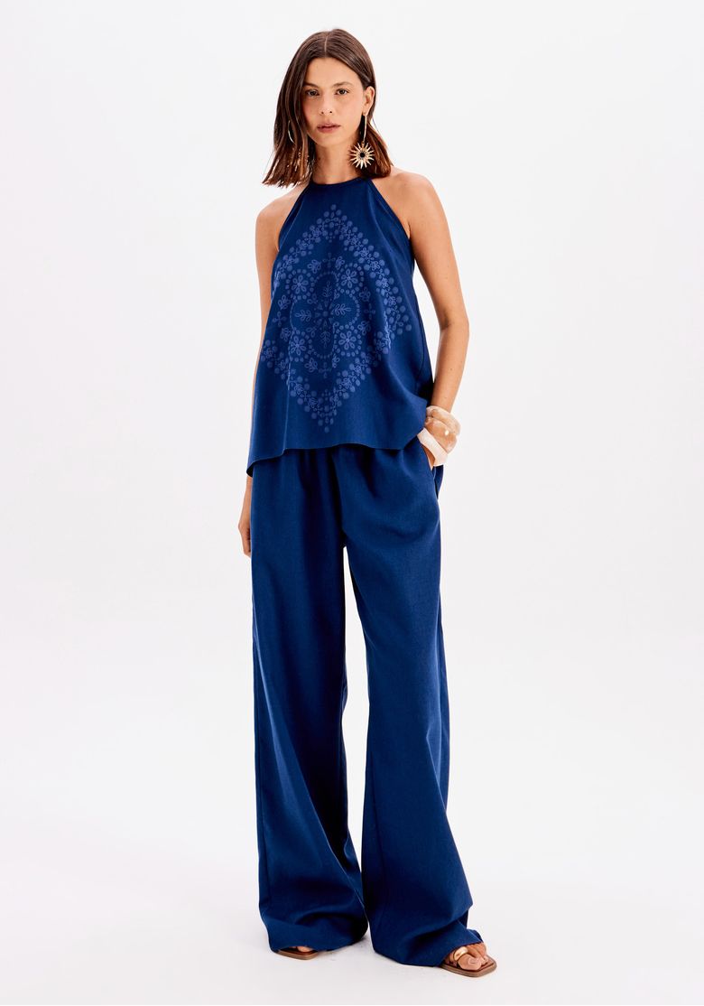 Look completo frontal: blusa frente única azul com decote halter e calça pantalona larga em azul, visual casual urbano elegante