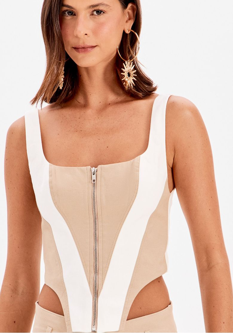 Blusa corset bege feminina com recortes off white, barra assimétrica e modelagem ajustada em produção fashion