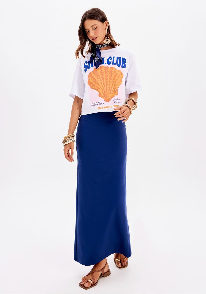 Modelo vestindo saia super midi azul com top branco, vista frontal.