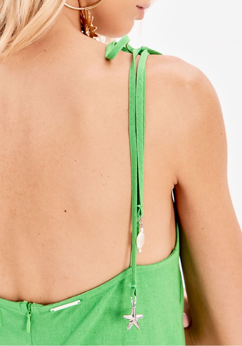 Costas do vestido mostrando zíper nas costas e alça amarrada com pingentes decorativos
