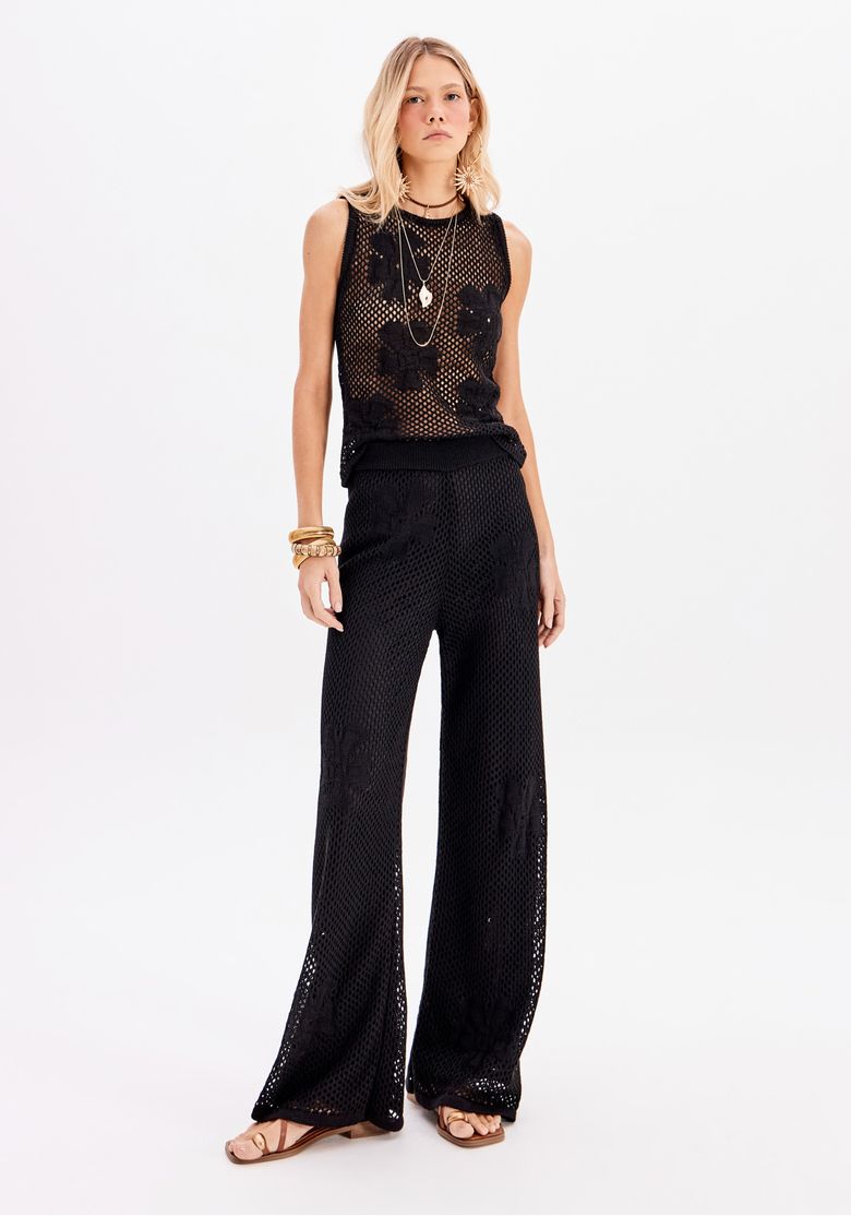 Calça tricô preta cintura alta vista frontal com top regata vazado; modelagem reta e caimento longo em look feminino
