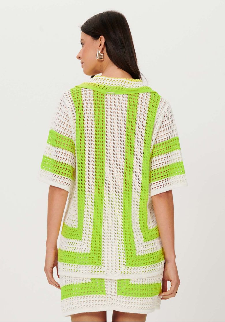 Look completo em modelo com camisa tricô oversized bege, saia de tricô combinando e sandália rasteira caramelo