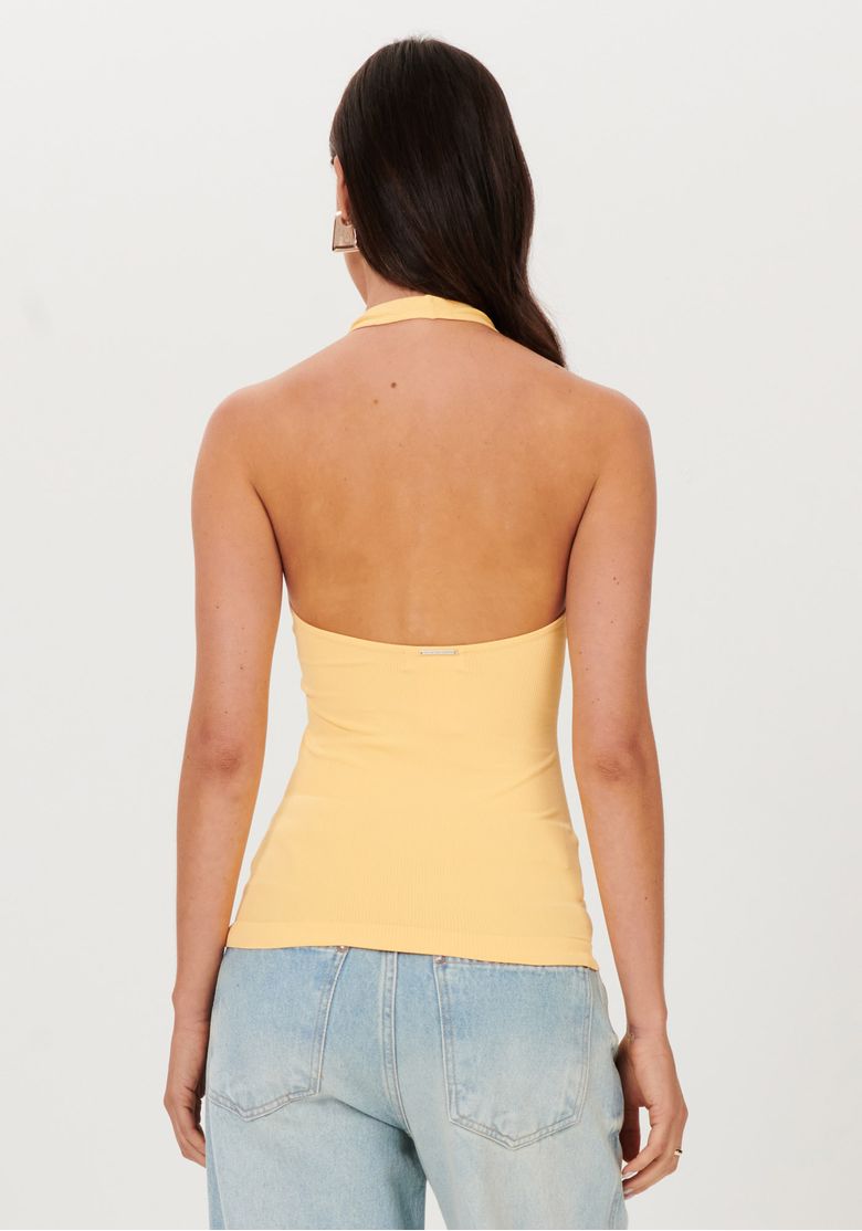 Visão traseira da blusa frente única laranja, mostrando as costas descobertas, a modelagem justa e o comprimento até a altura dos quadris.