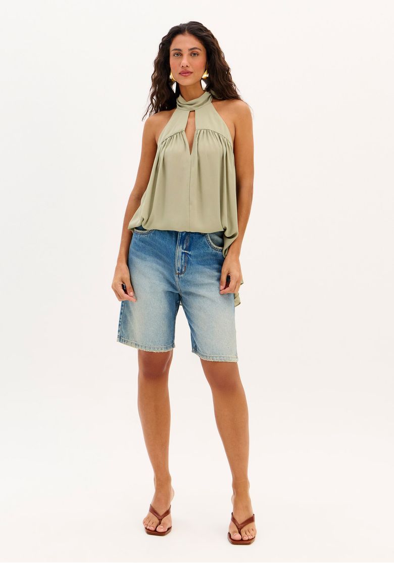 Modelo vestindo bermuda jeans comfort com top fluido em pose frontal.