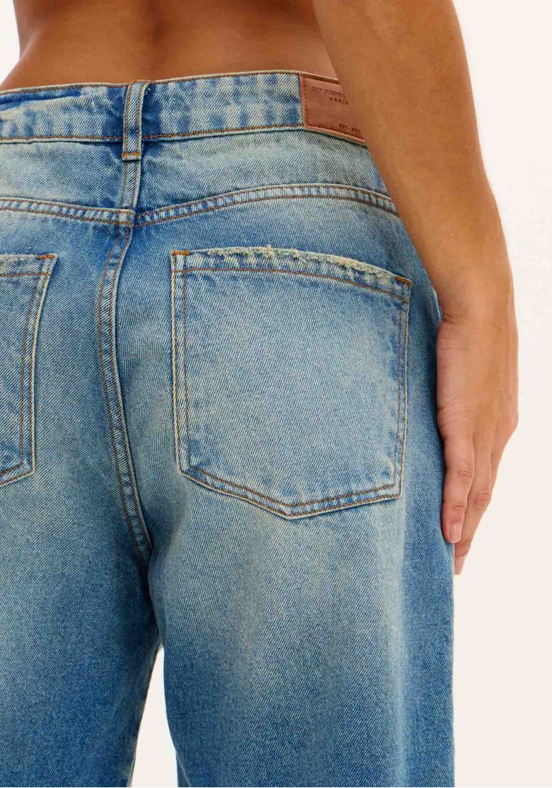 Vista traseira da bermuda jeans destacando os bolsos e o caimento.