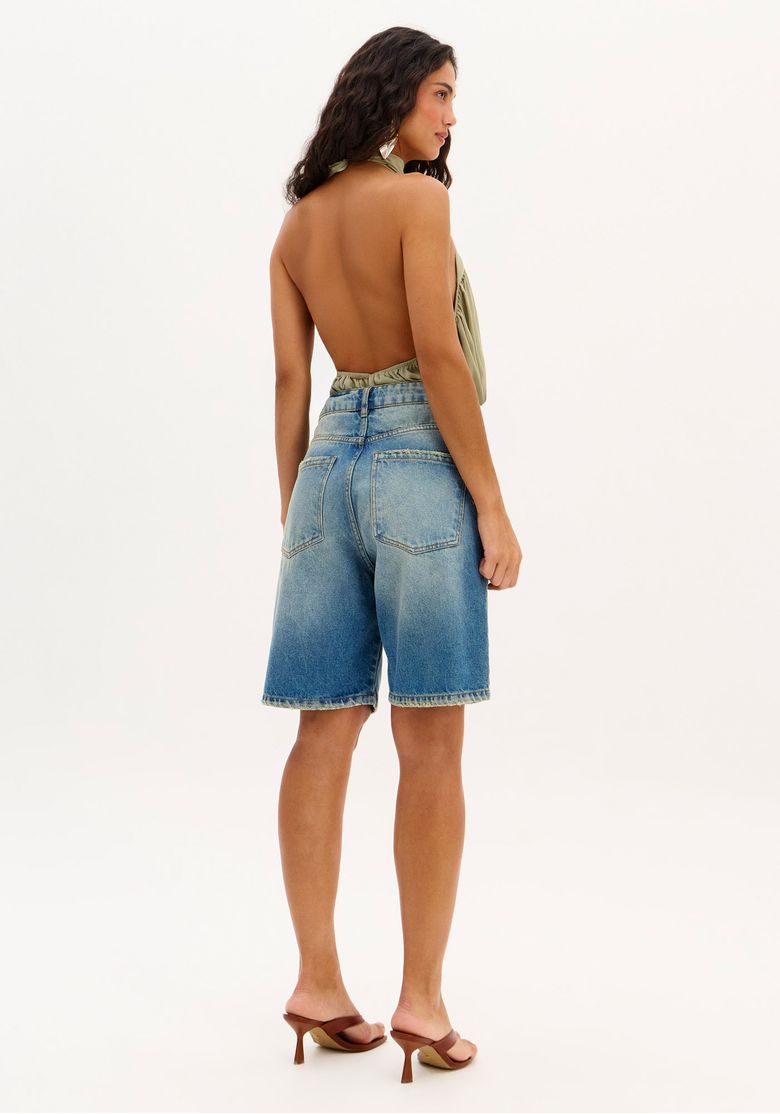 Detalhe do cós da bermuda jeans com passantes e acabamento.