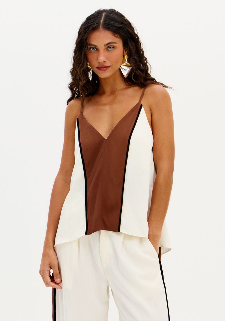Modelo usando blusa feminina de alças finas bicolor marrom e off white com decote em V profundo e caimento fluido, combinada com calça ampla
