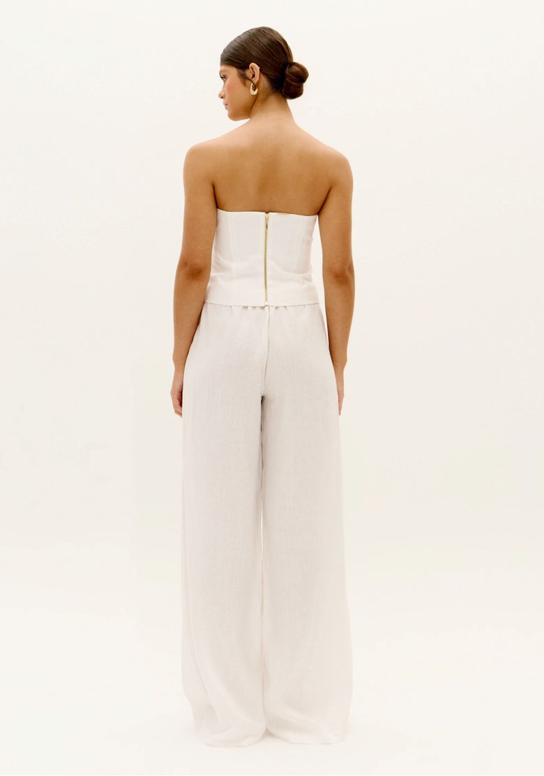 Vista traseira da calça wide leg branca com linho, modelagem longa e ampla, cintura alta e caimento fluido