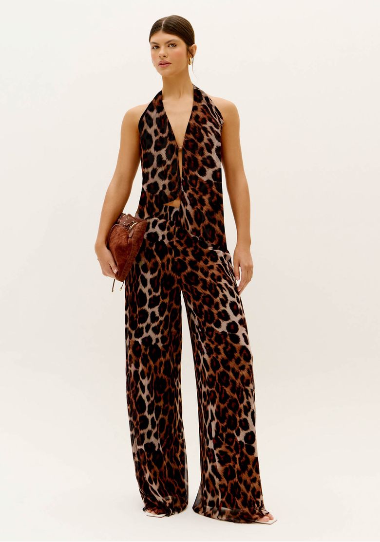 Modelo usando calça wide leg estampada animal print de onça em tule marrom com look de verão sofisticado