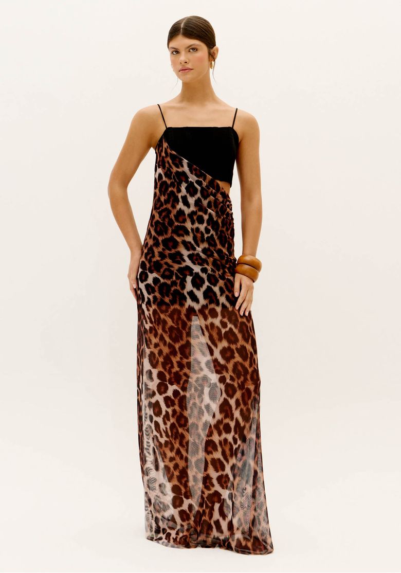 Modelo vestindo vestido longo em tule animal print com top preto reto, alças finas ajustáveis e recorte lateral cut out, visão frontal mostrando caimento fluido e transparência sutil