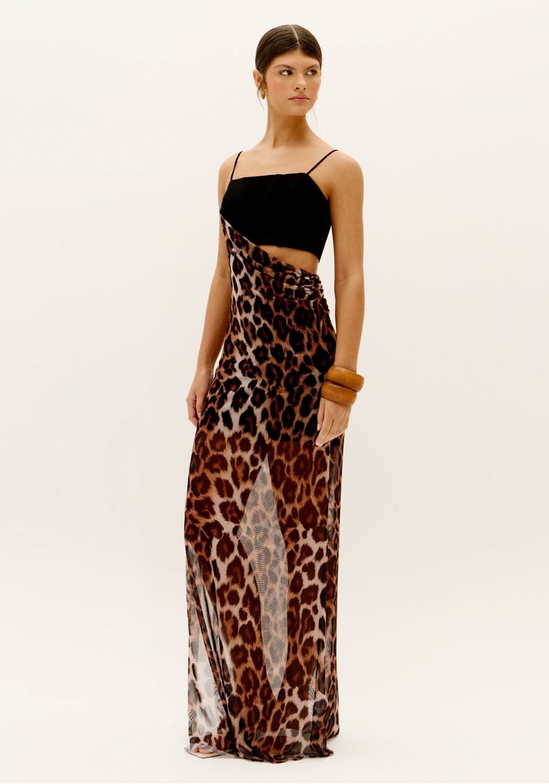 Visão em três quartos do vestido longo animal print com cut out lateral e fenda frontal reta, destaque para o movimento do tecido translúcido