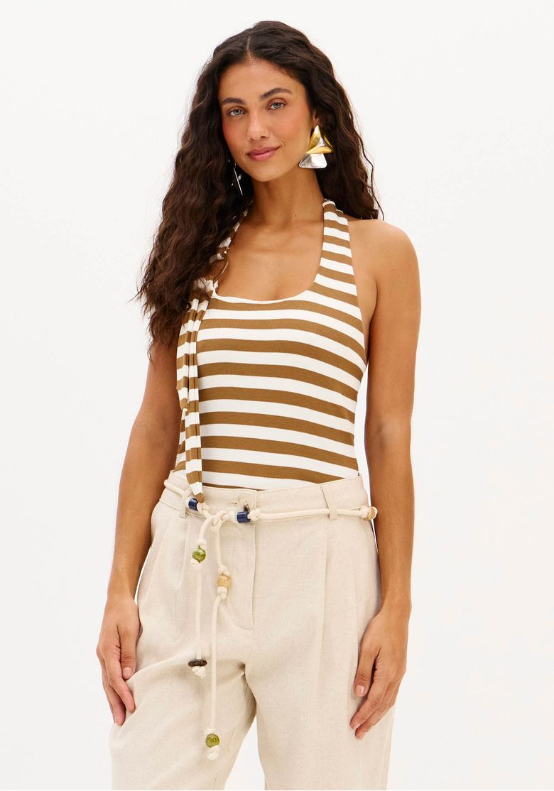 Look com body halter top listrado marrom e branco e calça bege de cintura alta em um estilo casual urbano.