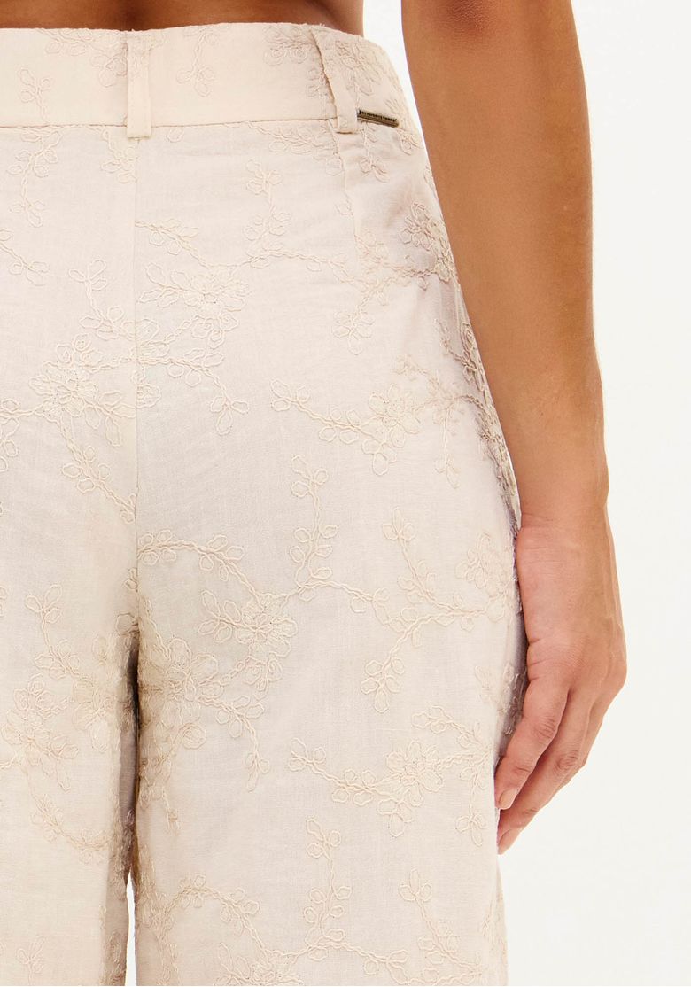 Vista traseira da calça full length bege em modelagem ampla, comprimento longo e caimento elegante, modelo de costas