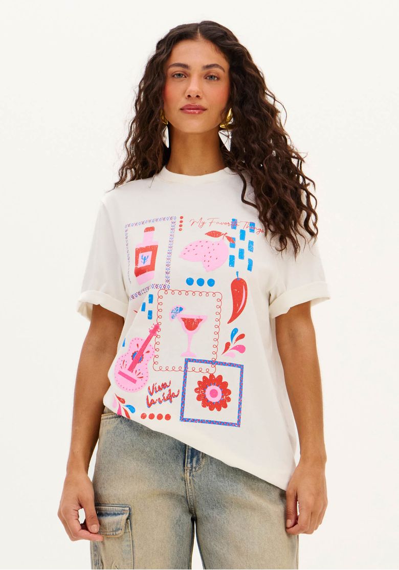 Modelo vestindo camiseta oversized alongada branca com estampa vibrante, vista frontal.