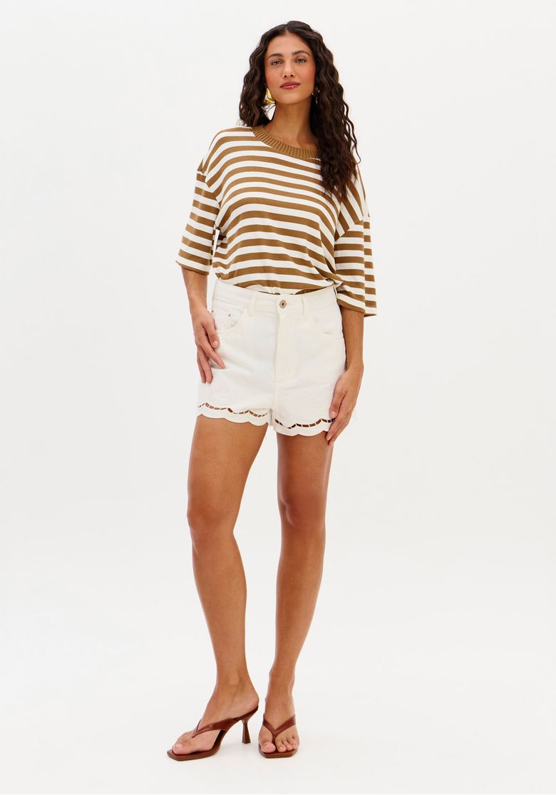 Modelo em pé vestindo short sarja mom branco cintura alta com camiseta listrada, demonstrando caimento frontal e comprimento curto.