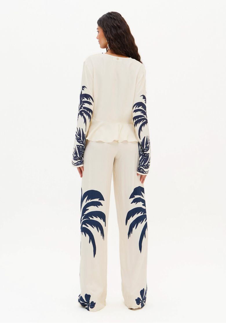 Detalhe da estampa tropical azul na perna da calça.