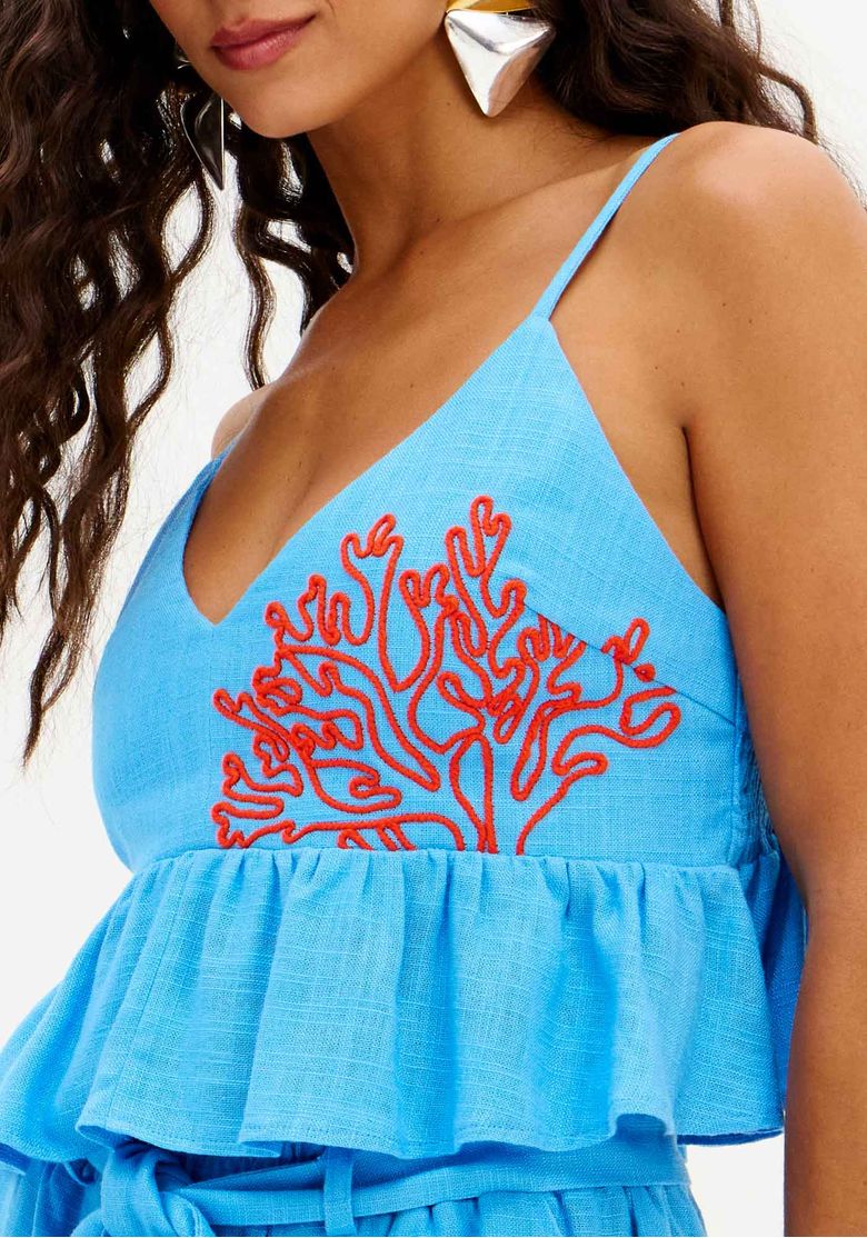 Conjunto top cropped e shorts de linho azul com faixa na cintura, look verão exibido em modelo com sandálias gladiador