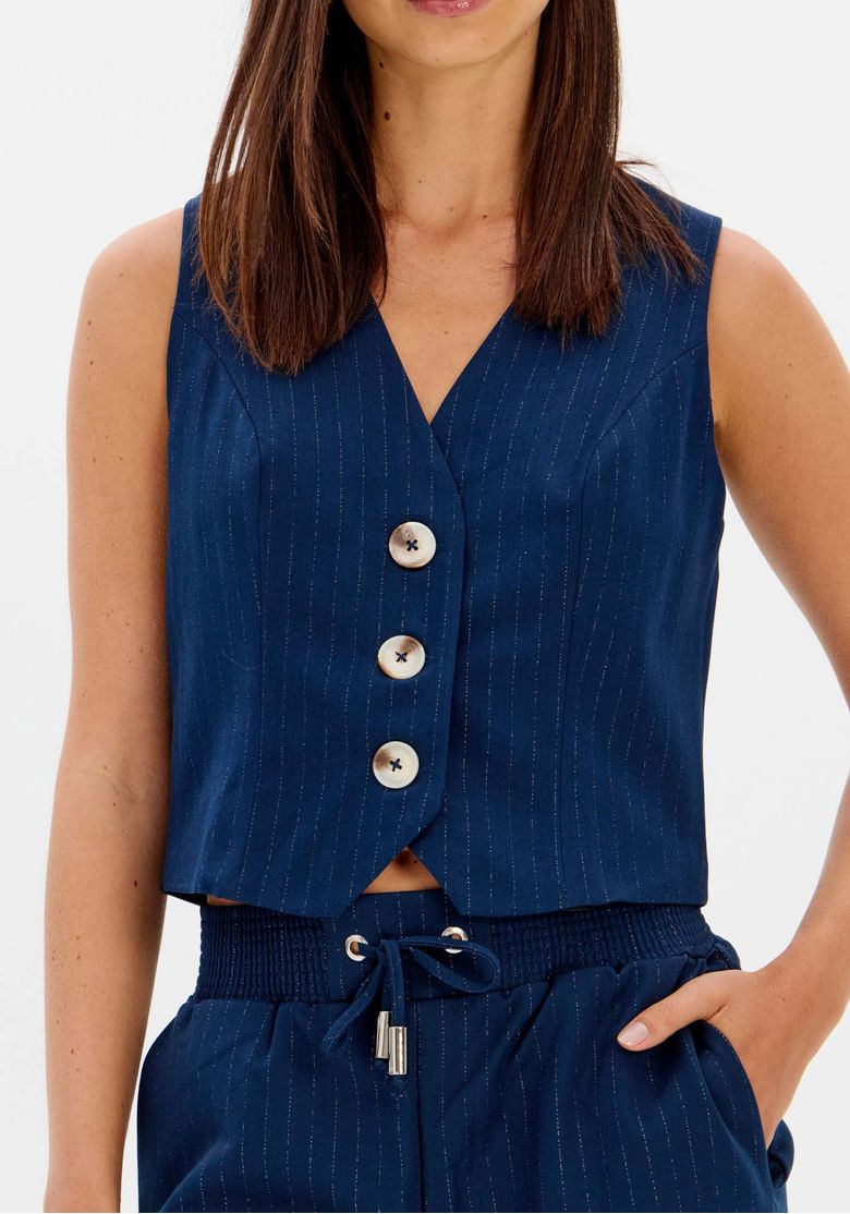 Look completo: colete cropped risca de giz azul combinado com calça pantalona risca de giz, mostrando caimento fluido e cintura elástica com cordão