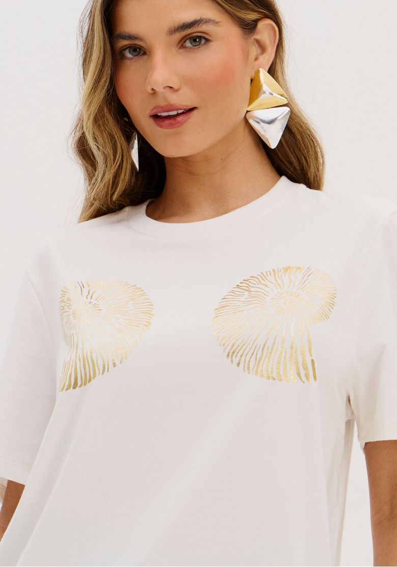 Detalhe da estampa dourada na camiseta branca.