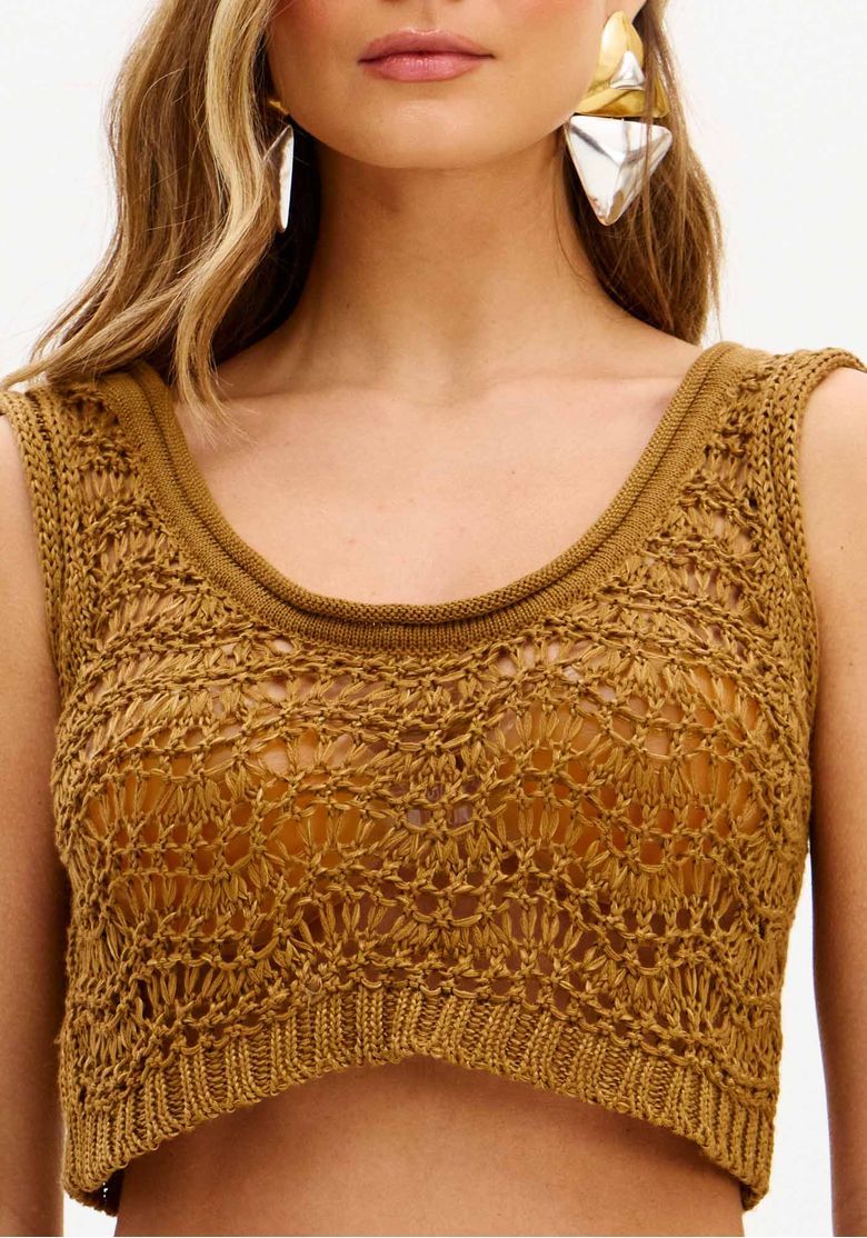 Visual completo em perfil do conjunto de tricô na cor marrom: top cropped e calça flare em textura aberta, ideal para ocasiões casuais ao entardecer.