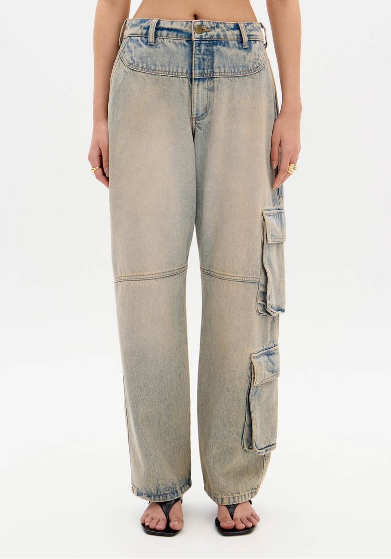 Detalhe frontal da calça jeans baggy com bolsos utilitários.
