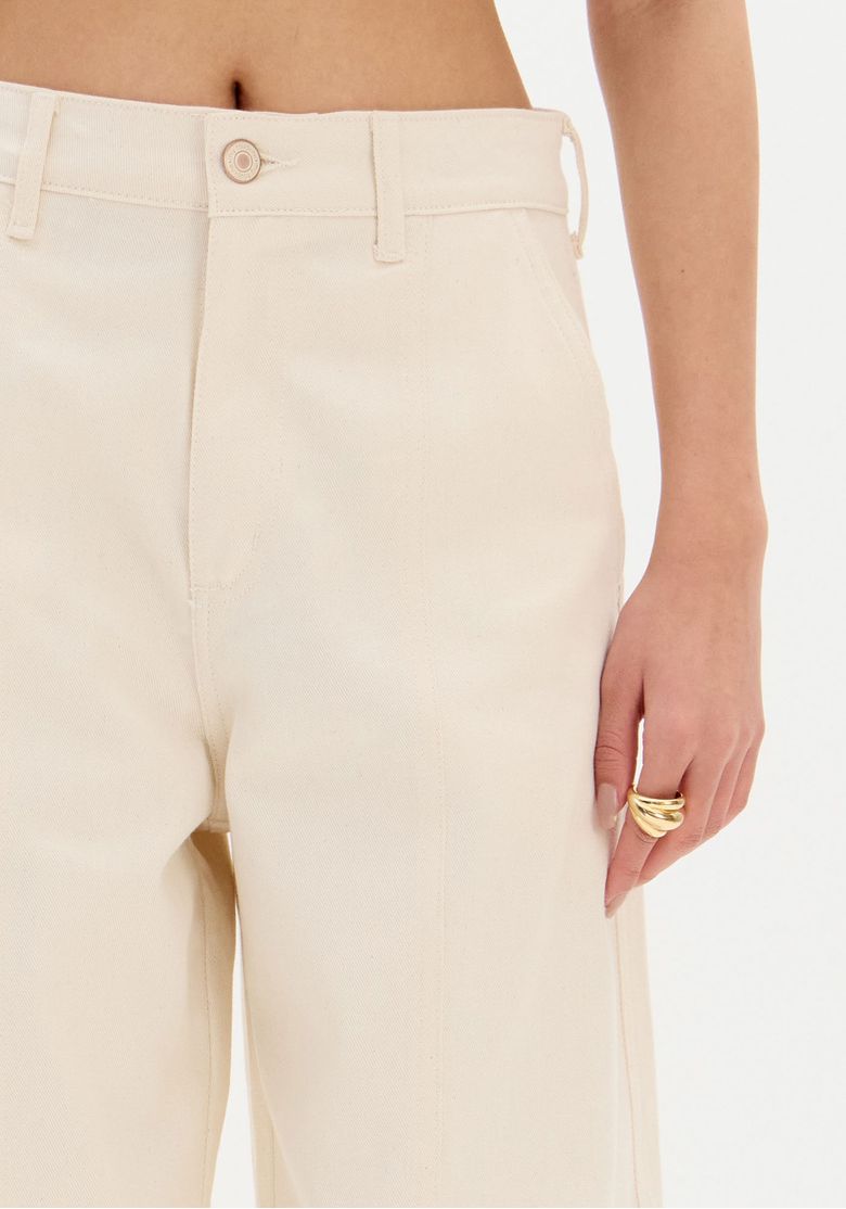 Vista traseira da calça sarja bege com bolsos cargo laterais e abas em contraste marrom