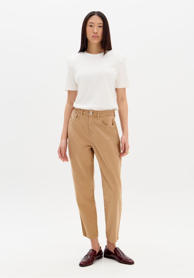 Modelo vestindo calça jeans mom marrom com camiseta branca, vista frontal.