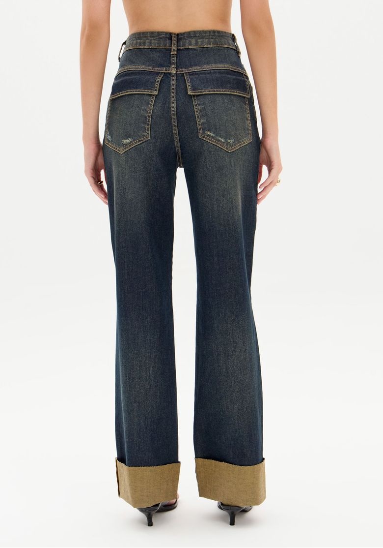 Vista traseira completa da calça jeans com barra virada larga, caimento reto e comprimento longo