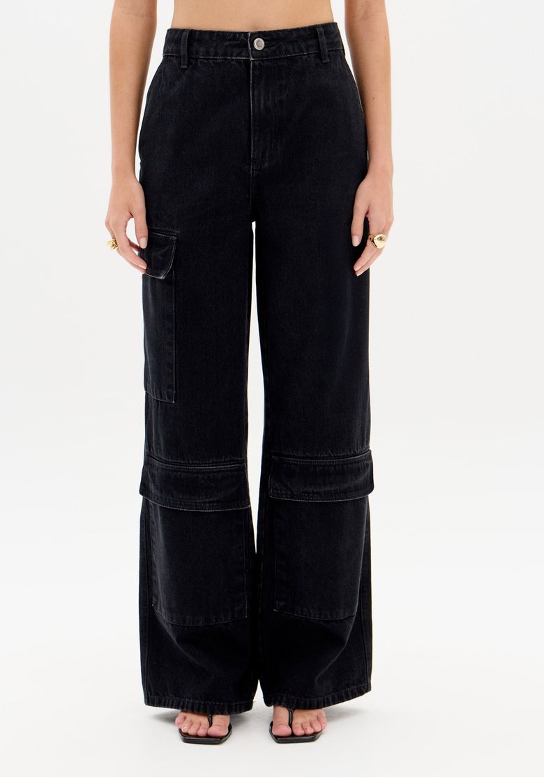 Frente da calça jeans preta full length em sarja com recortes horizontais e painel costurado na perna