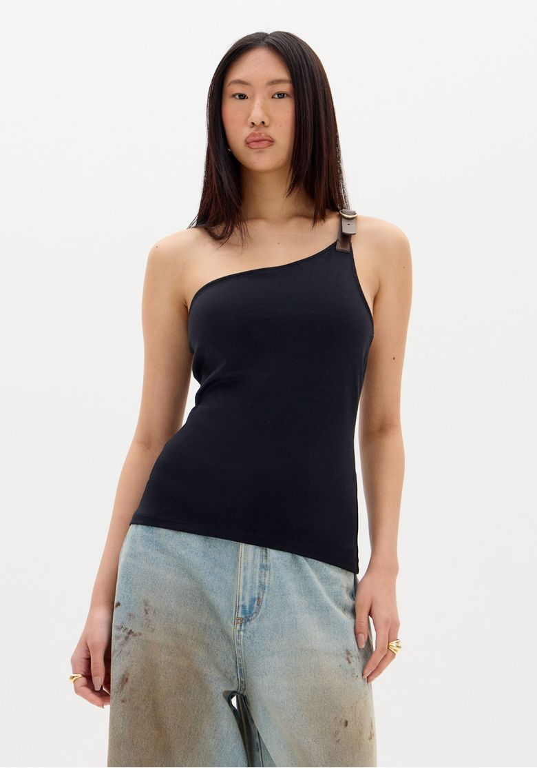 Modelo-em-pe-usando-blusa-ombro-unico-preta-com-fivela---vista-frontal-em-tres-quartos-caimento-justo-e-malha-pesada