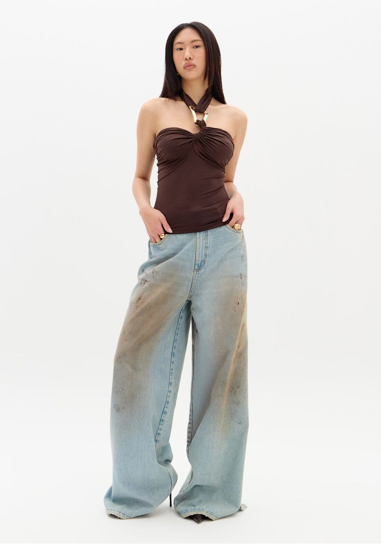 Vista completa da blusa frente única marrom com calça jeans ampla.