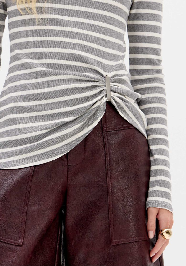 Visão de corpo inteiro da blusa listrada gola alta combinada com bermuda vinho e botas cano médio, look casual urbano