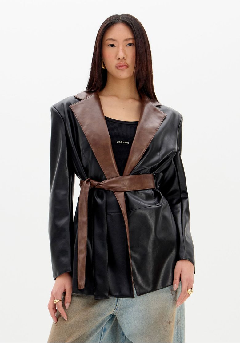 Blazer oversized bicolor preto e marrom com faixa ajustável na cintura, em fundo branco.