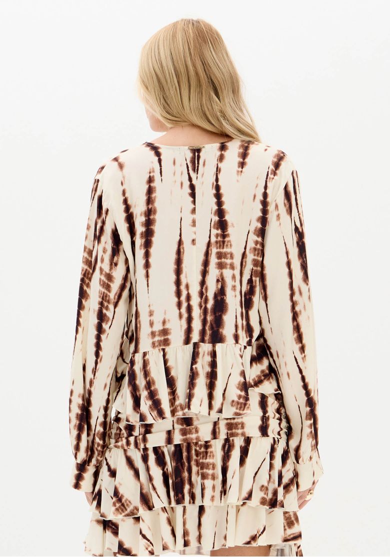 Foto em corpo inteiro da modelo usando blusa bata estampada em viscose e botas cano médio, look boho-chic casual urbano