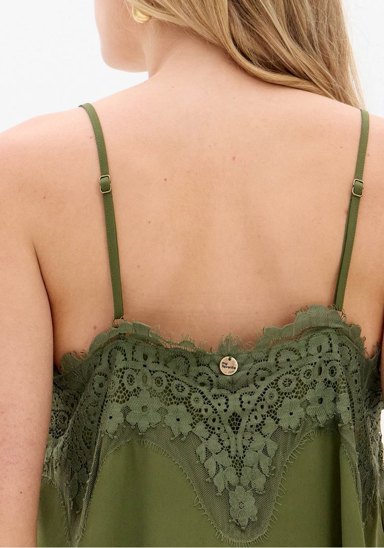 Detalhe do tecido e renda da blusa de alça verde.