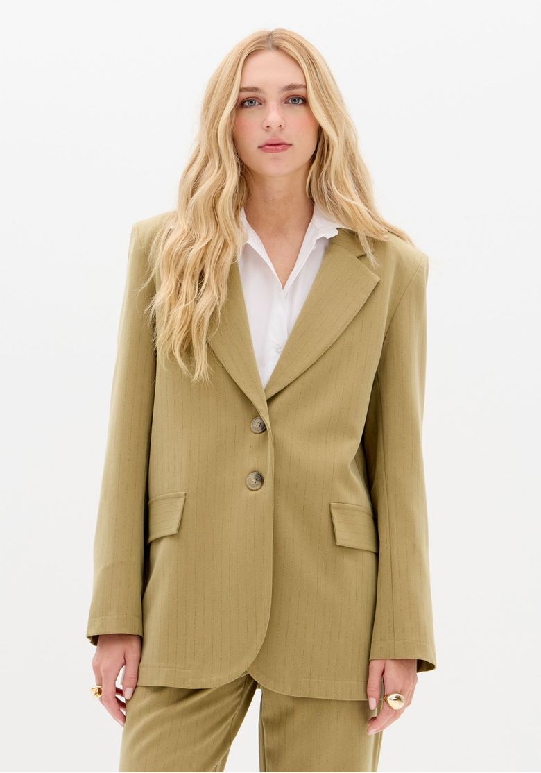 Modelo frontal com blazer oversized alfaiataria verde risca de giz, fechamento em dois botões e bolsos com aba, look trabalho