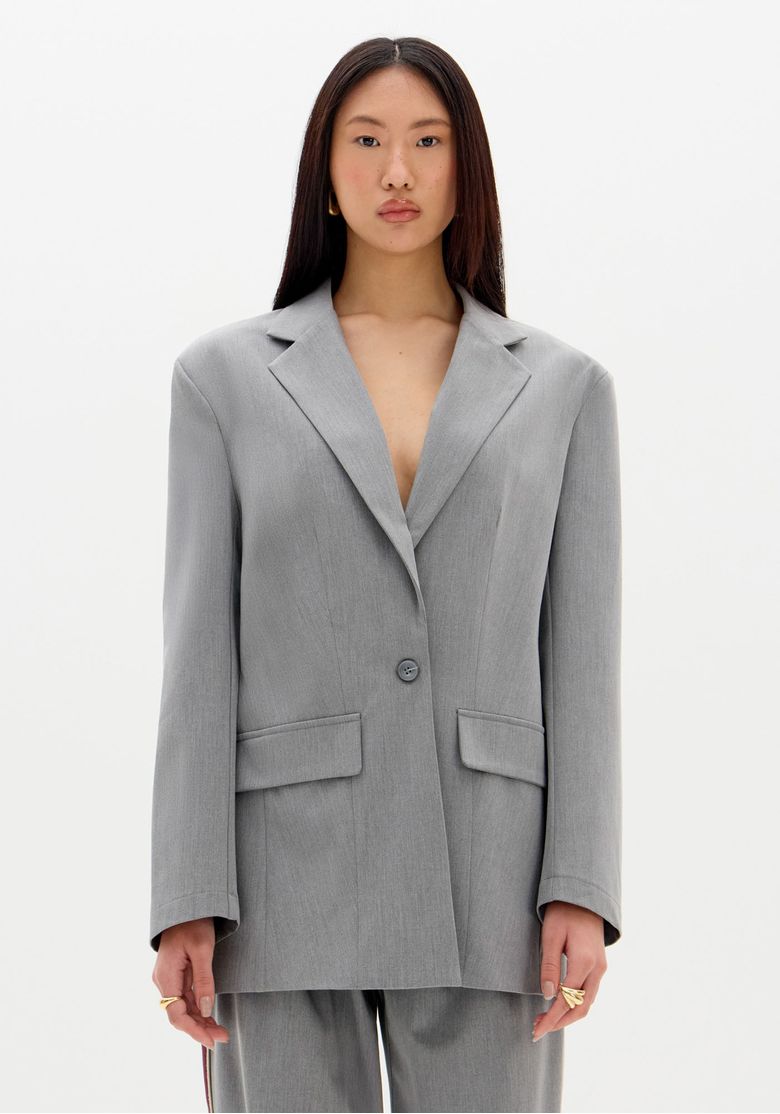 Modelo vestindo blazer oversized cinza, visual frontal sem acessórios.