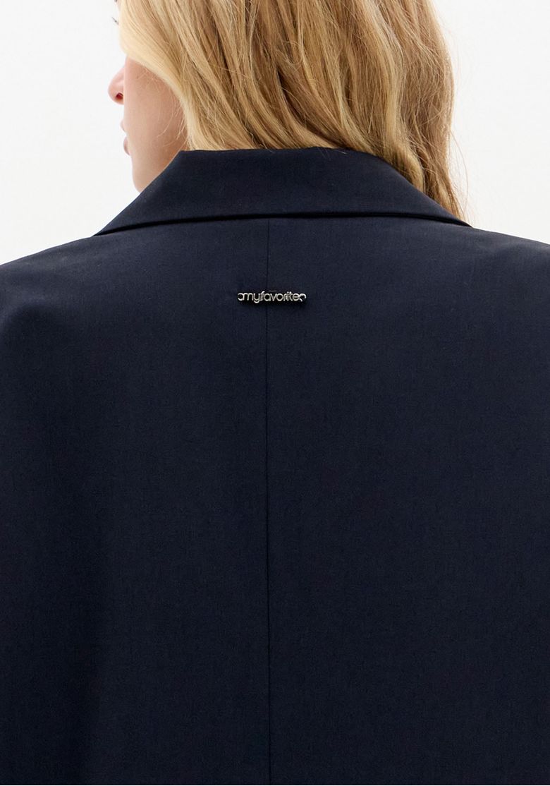 Detalhe da parte traseira do blazer azul com acabamento refinado.