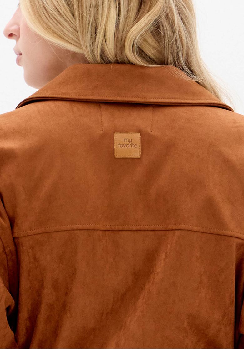 Close-up das costas da camisa camurça marrom com etiqueta discreta em material sintético e textura aveludada