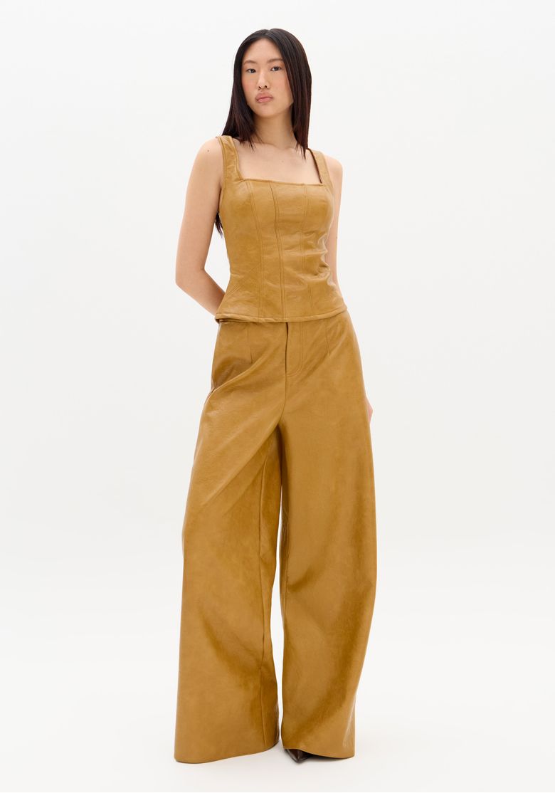 Modelo vestindo calça Palazzo bege com top ajustado, vista frontal.